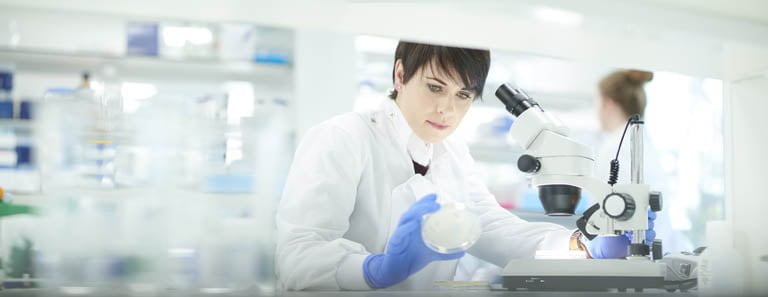 Vrouwelijke wetenschapper in een druk onderzoekslaboratorium (iStock)